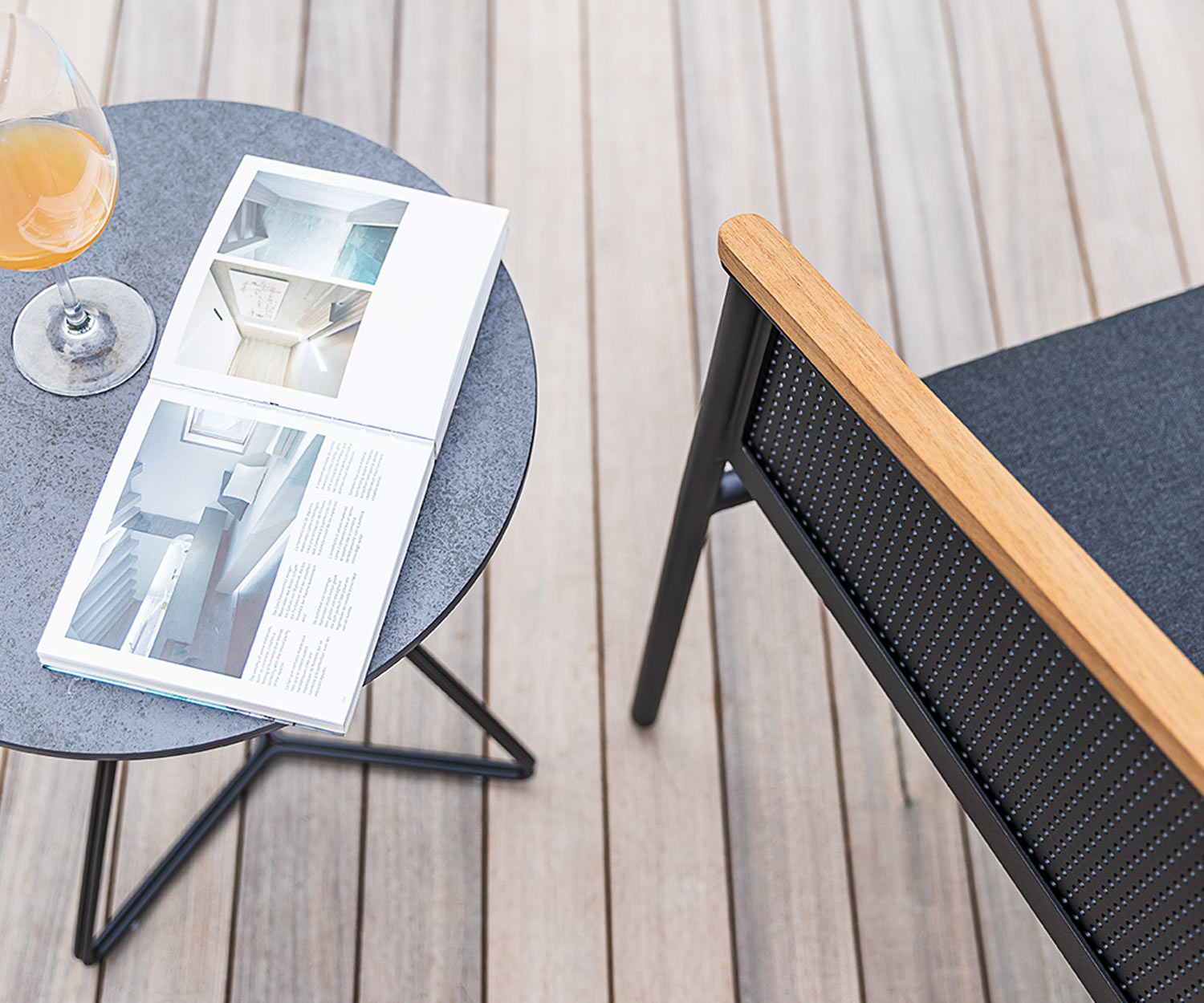 Moderner Oasiq Riad Gartensessel auf Terrasse im Detail die Teak Armlehne Moderner Oasiq Riad Gartensessel auf Terrasse im Detail die Teak Armlehne