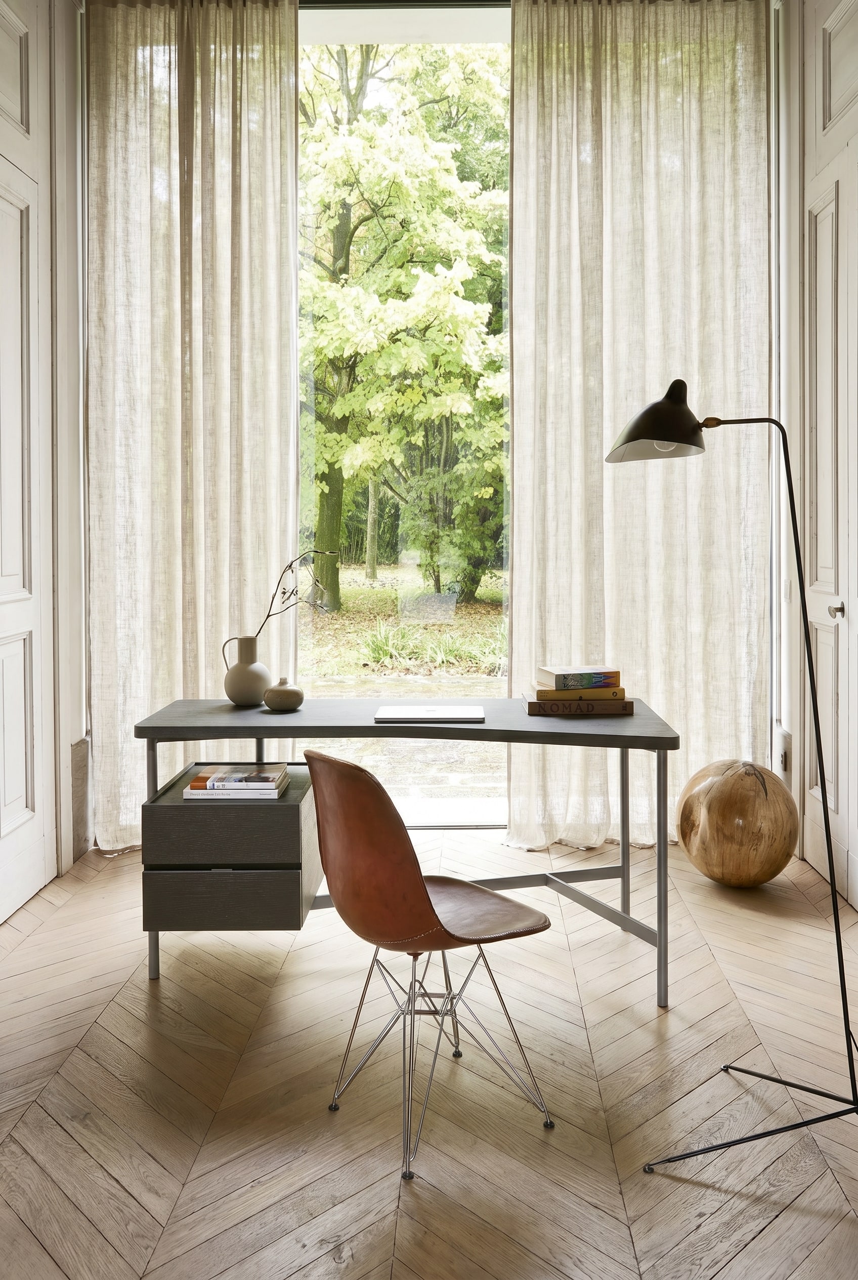 Ein sehr schlanker, minimalistischer Schreibtisch mit Metallgestell in einem hellen Gästezimmer. Ein sehr schlanker, minimalistischer Schreibtisch mit Metallgestell in einem hellen Gästezimmer.