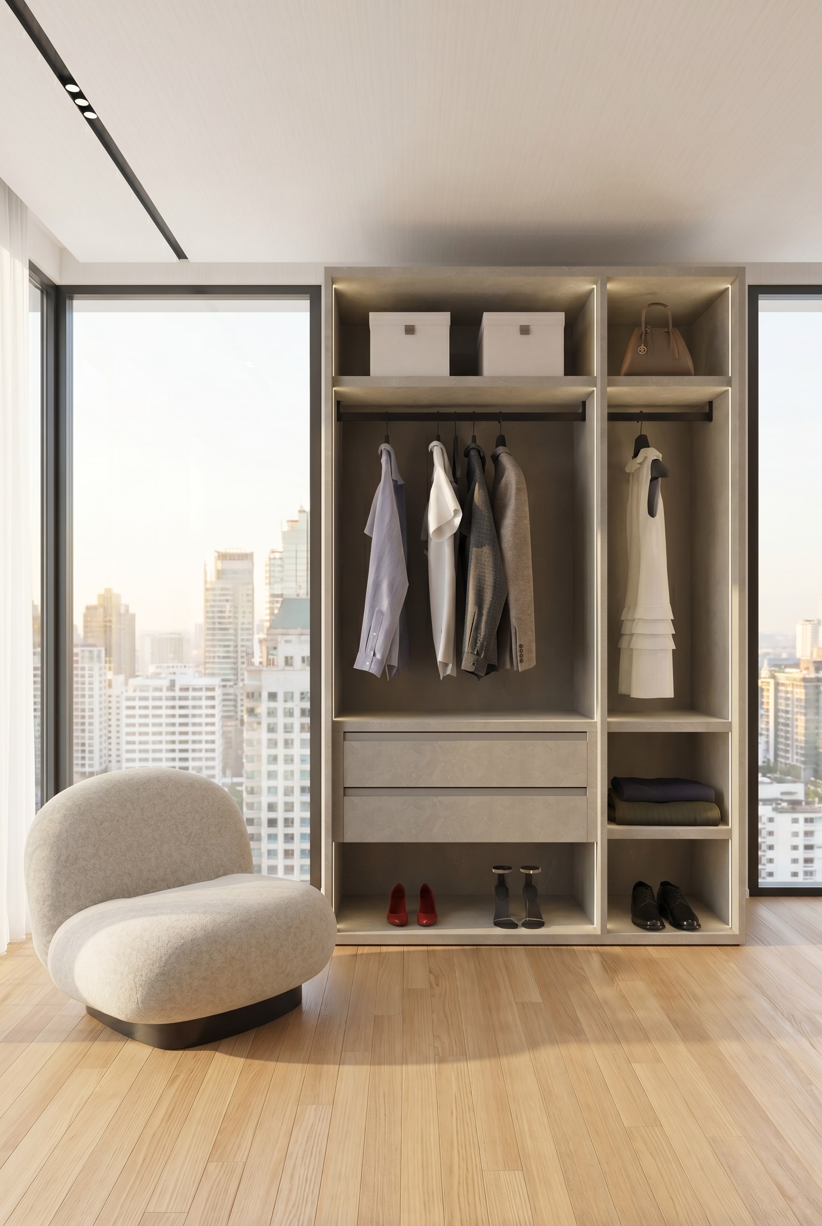 Modernes Ankleidezimmer mit einem rahmenlosen offenen Kleiderschranksystem in strukturiertem Greige, h&auml;ngenden Leinenhemden und einem Lounge-Sessel im warmen Morgenlicht