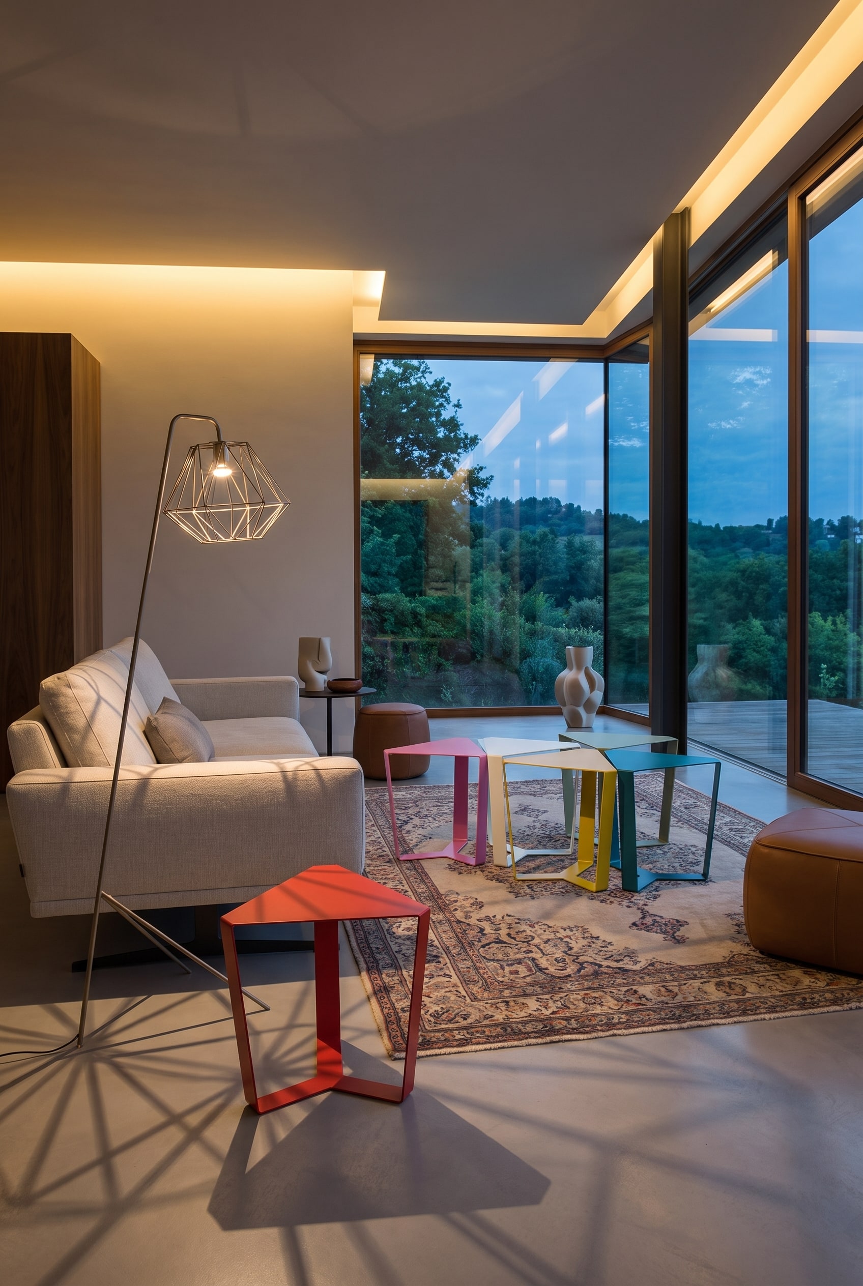Ein helles Wohnzimmer mit dem Couchtisch Coral von Punt, dessen offenes Gestell den Blick auf einen modernen Teppich freigibt.