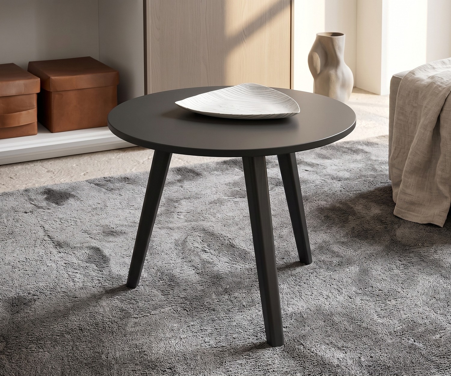 Runder Design Beistelltisch Trio Wohnzimmer-Beistelltisch Trio von Novamobili. Runder, dunkelgrauer Design-Tisch mit drei Holzbeinen auf grauem Teppich.