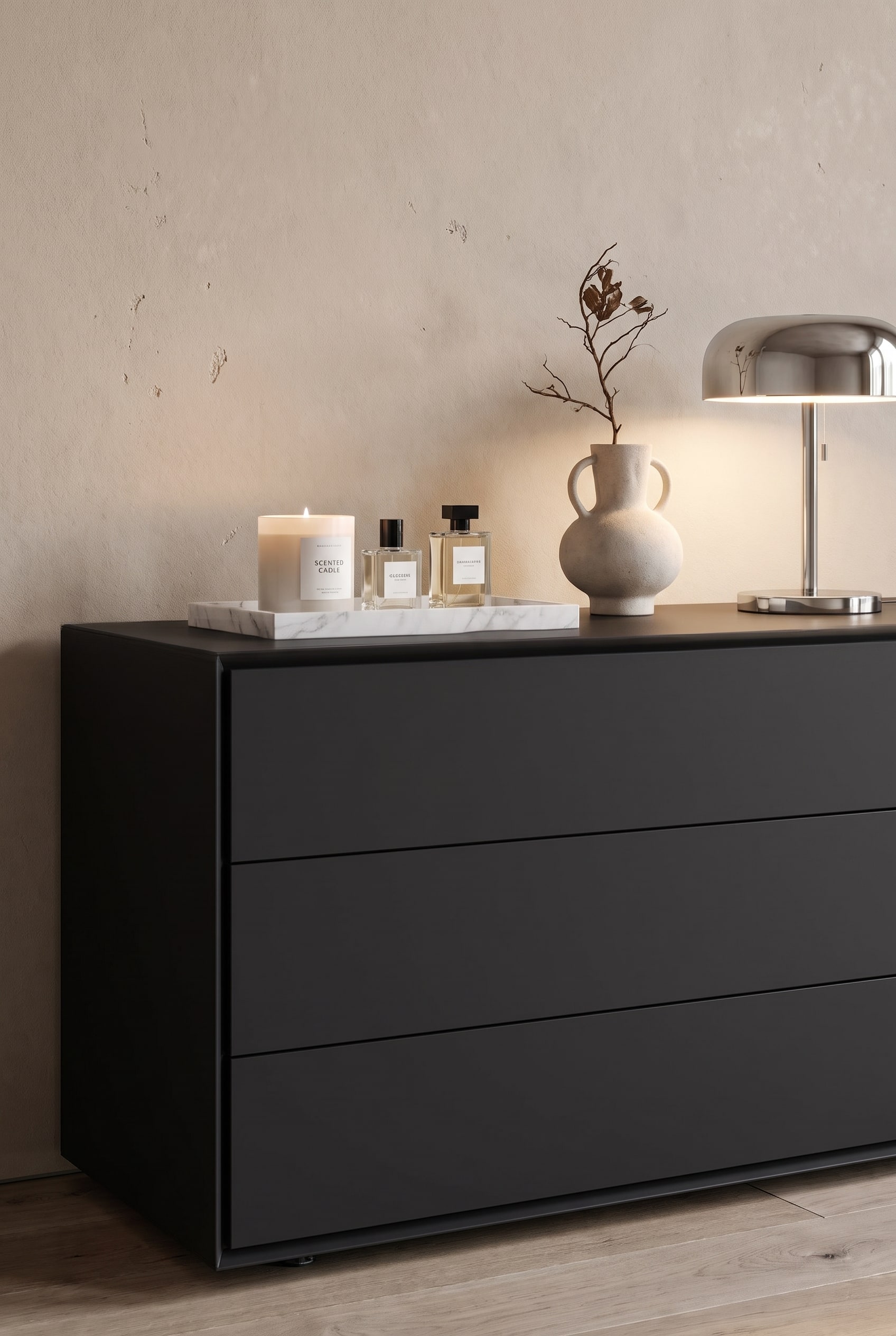 Matte Design-Kommode im Wohn-Schlafbereich, darauf gestapelte Bildbände, eine skulpturale Vase und eine kleine Tischlampe