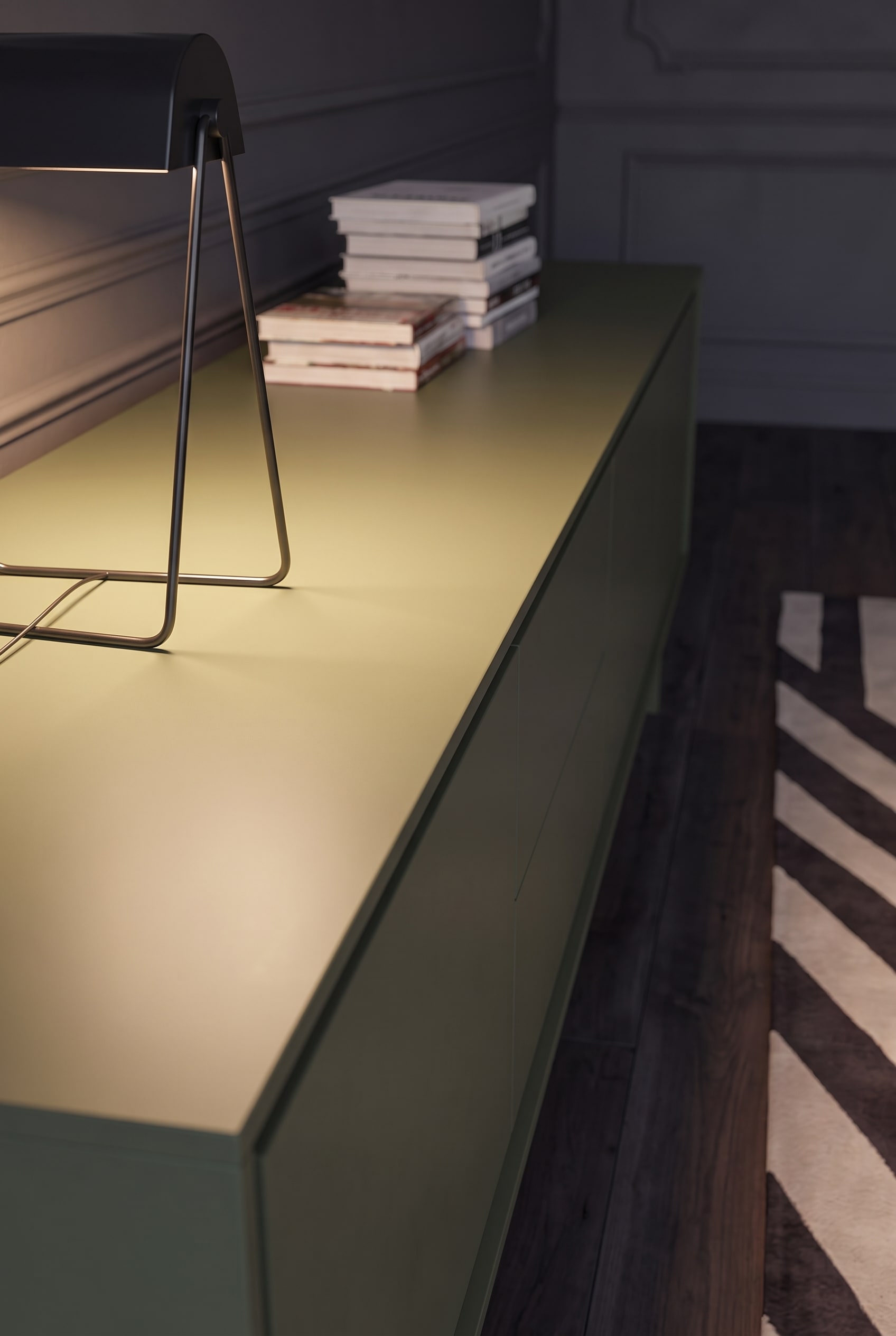 Makroaufnahme der glatten, matt lackierten Abdeckplatte eines olivgr&uuml;nen Sideboards.