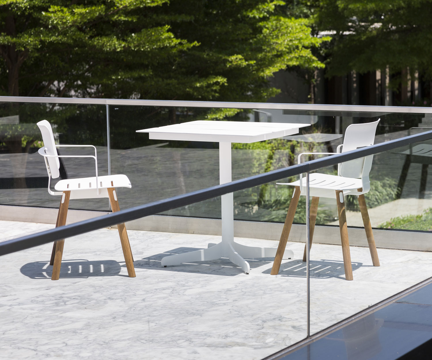 Weißer Oasiq Ceru Design Gartentisch mit zwei Gartenstühlen auf Terrasse Weißer Oasiq Ceru Design Gartentisch mit zwei Gartenstühlen auf Terrasse