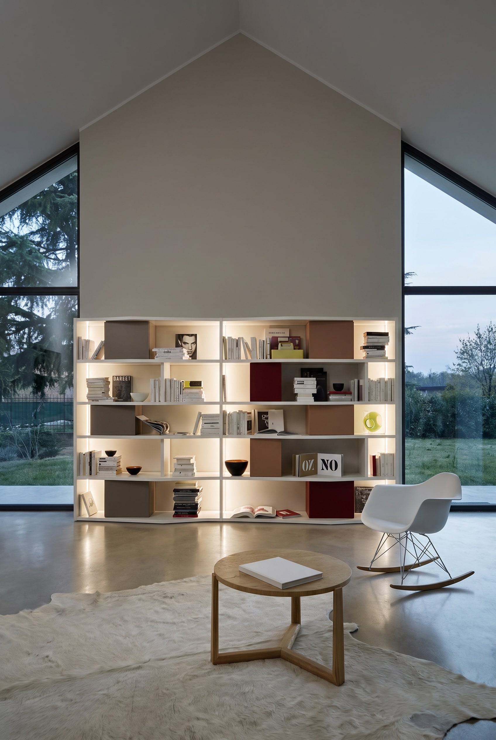 Hohes, wei&szlig;es B&uuml;cherregal an einer geraden Giebelwand im Dachgeschoss, best&uuml;ckt mit B&uuml;chern und farbigen Aufbewahrungsboxen