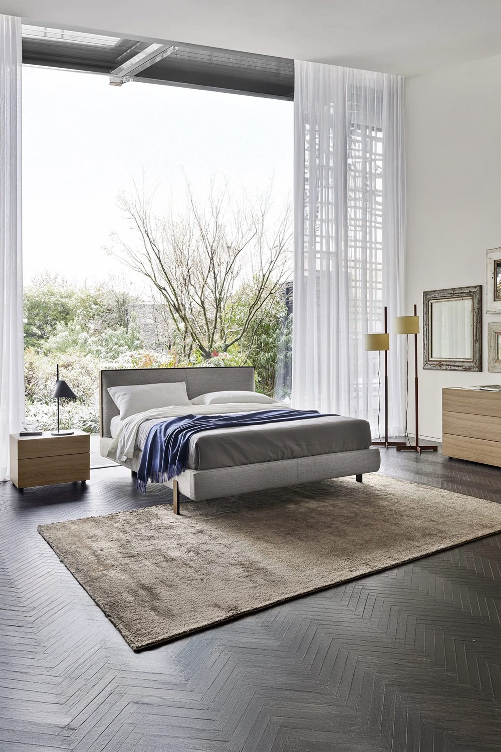 schlank-gerahmtes-bett-mit-schwebendem-effekt-und-griffloser-nachttisch-vor-einem-grossen-fenster