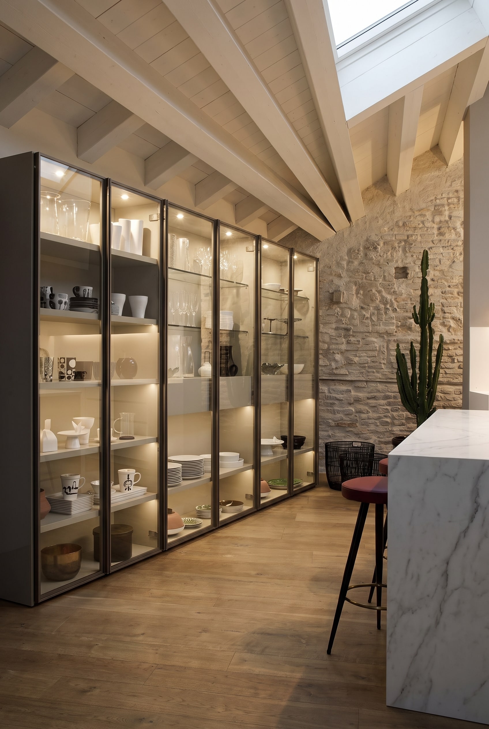 Hohe Glasvitrine mit feinem Metallrahmen und sanfter LED-Innenbeleuchtung in einem eleganten Esszimmer