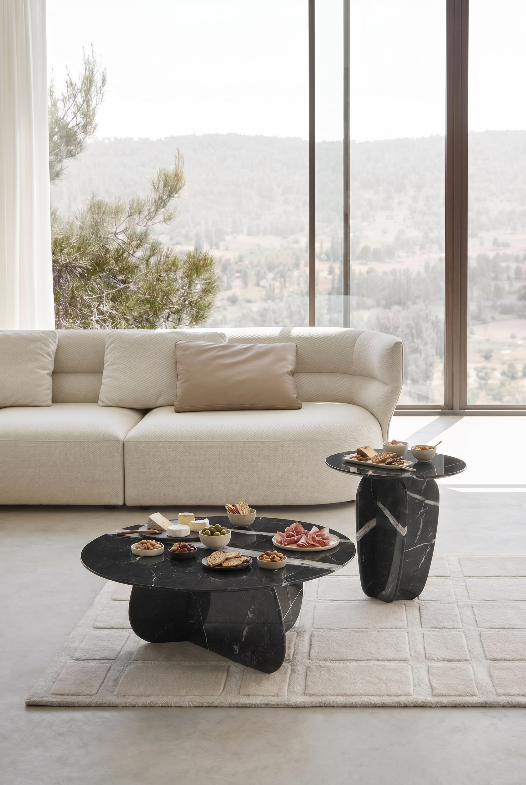 Elegantes Wohnzimmer mit zwei runden Marmor-Couchtischen vor einem beigefarbenen Stoffsofa auf einem hellen Teppich