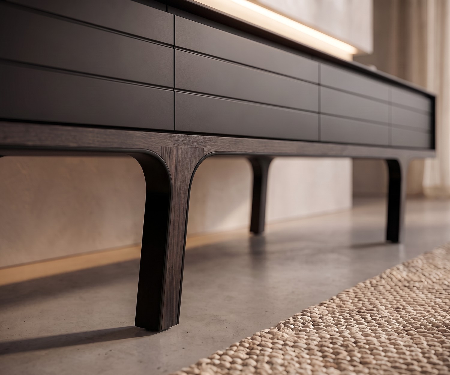 al2 Mobius 004 TV-Lowboard im Wohnzimmer unter Fernseher, dunkles Design mit Holzbeinen vor grauer Betonwand.