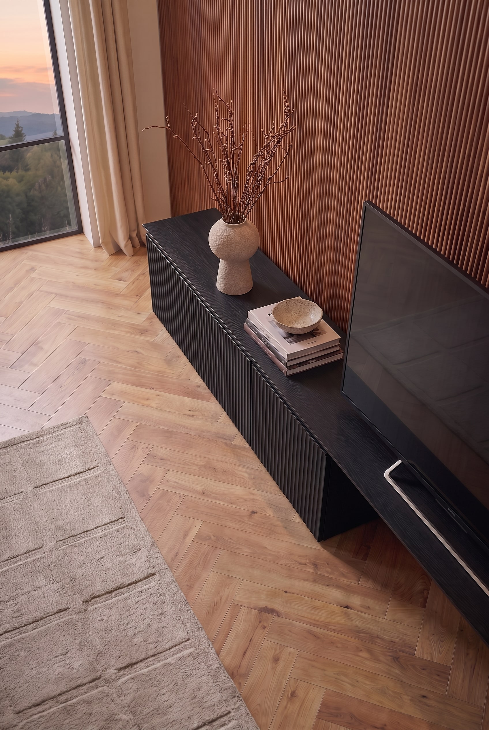 Schr&auml;ge Aufsicht auf das schwarze TV-Lowboard. B&uuml;cher, eine Schale und eine Vase lockern die Fl&auml;che neben dem Bildschirm auf.