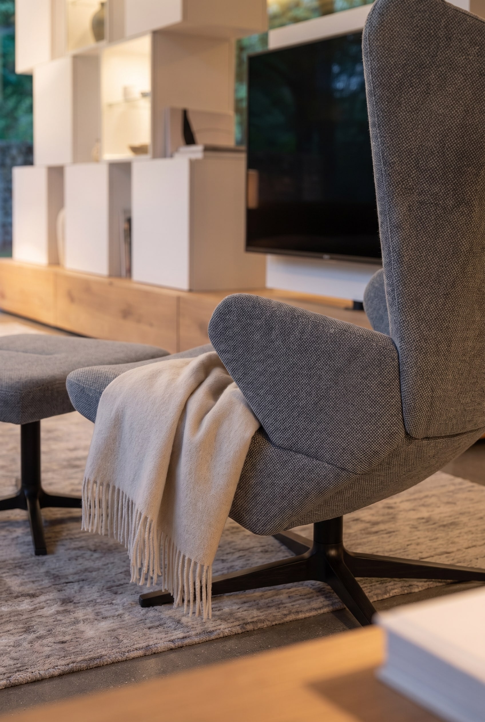 Ein moderner Sessel Prostoria Trifidae steht gemütlich neben einem eleganten Raumteiler im Wohnzimmer
