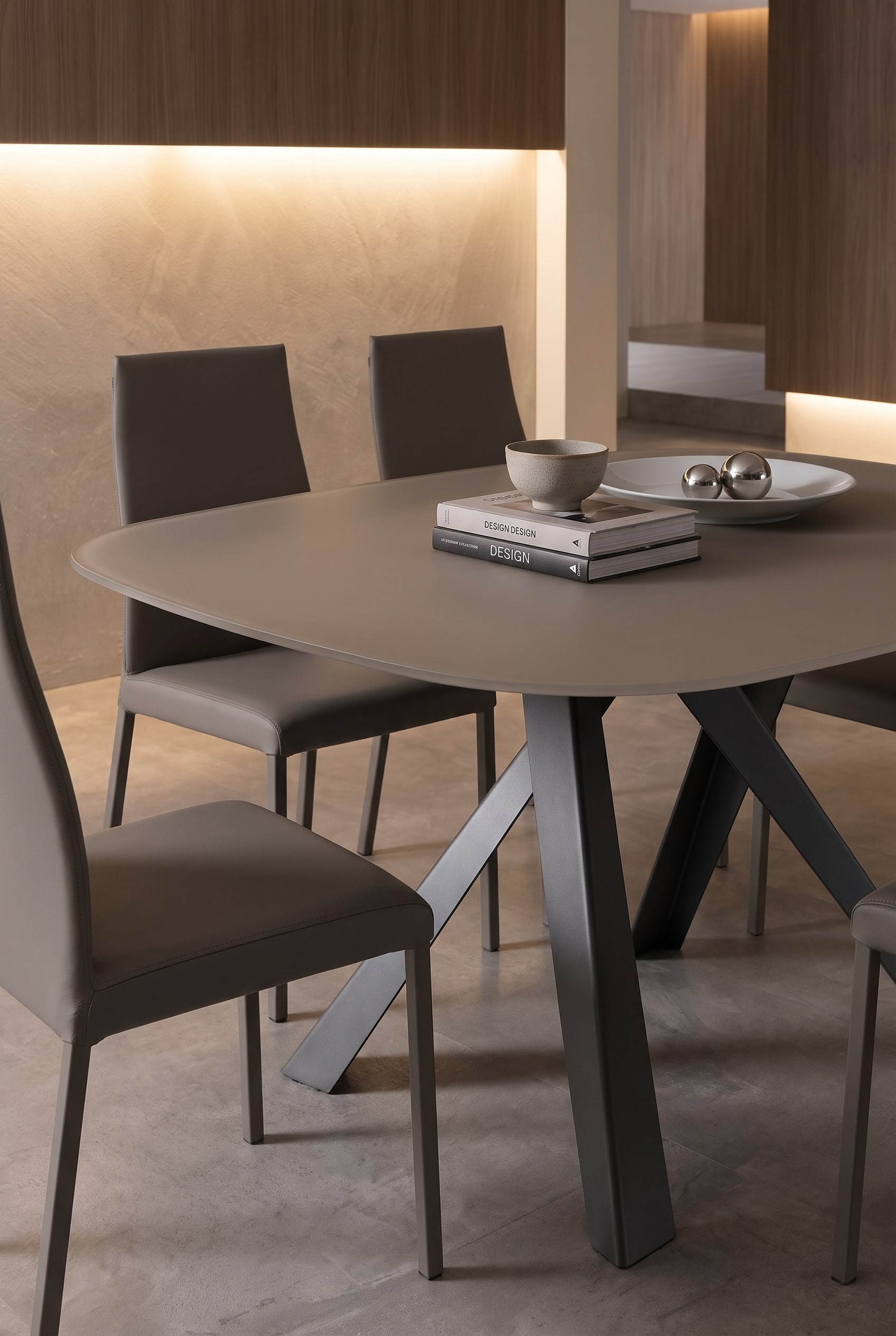 Filigraner Ozzio Esstisch Bombo mit dünner kratzfester Platte und eleganten Esszimmerstühlen in warmem Licht