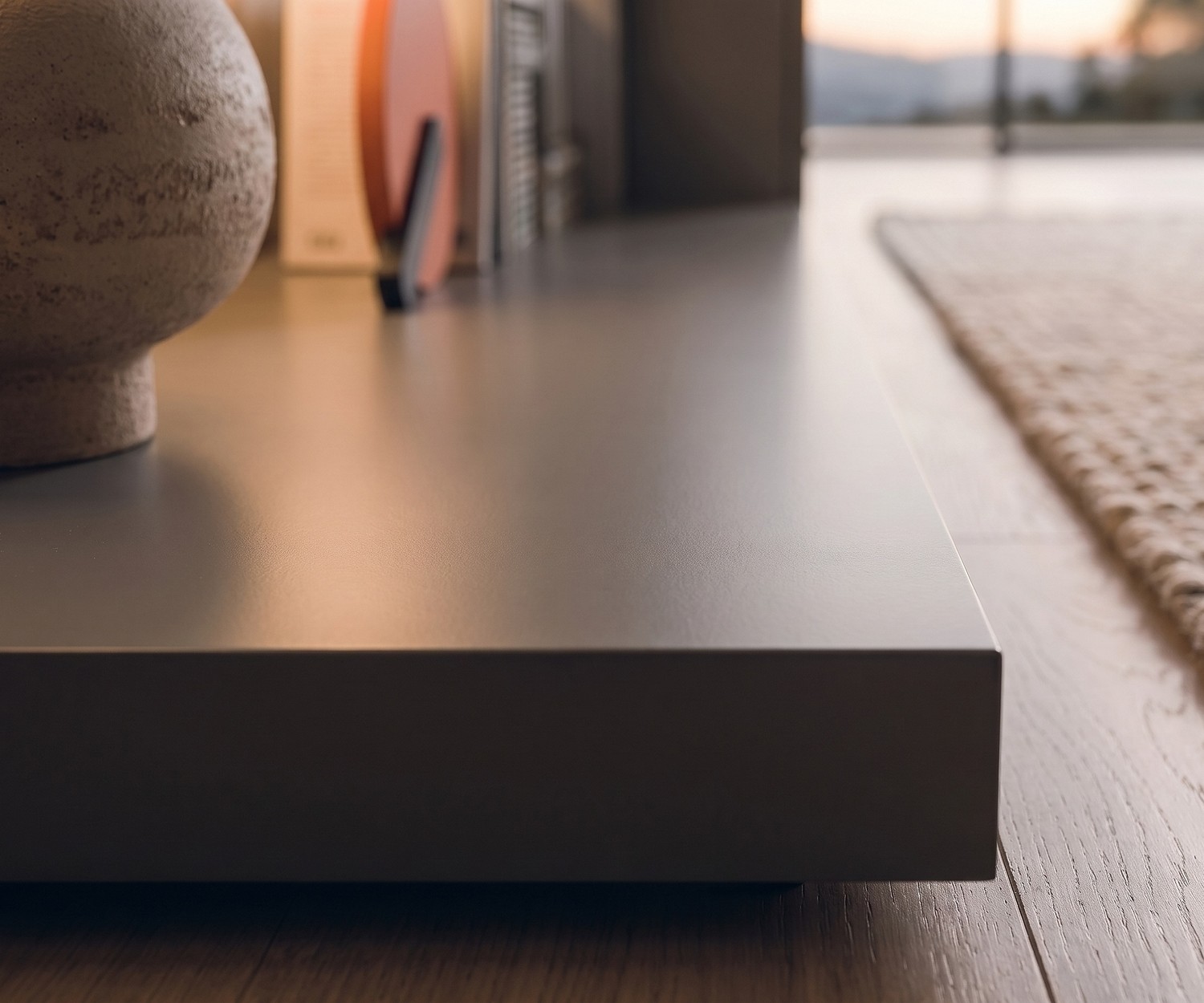 Livitalia Easy TV Podest als flacher Sockel im Wohnzimmer. Moderner grauer Sockel auf Holzparkett.