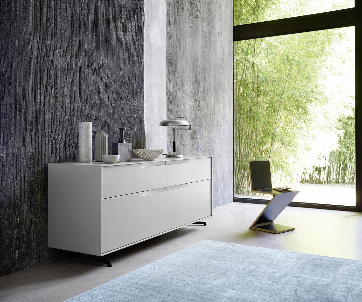 Designer Kommode Vela matt lackiert Grau im Schlafzimmer vor Fensterfront Designer Kommode Vela matt lackiert Grau im Schlafzimmer vor Fensterfront