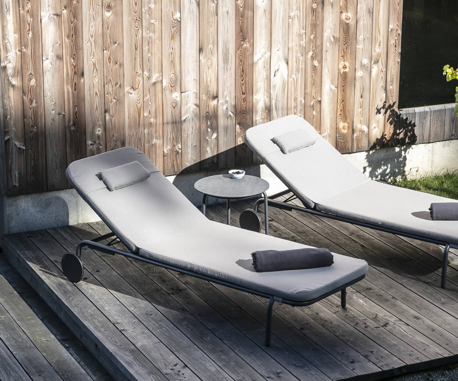 Design Beistelltisch Starling von Todus mit zwei Gartenliegen auf Holzveranda Design Beistelltisch Starling von Todus mit zwei Gartenliegen auf Holzveranda