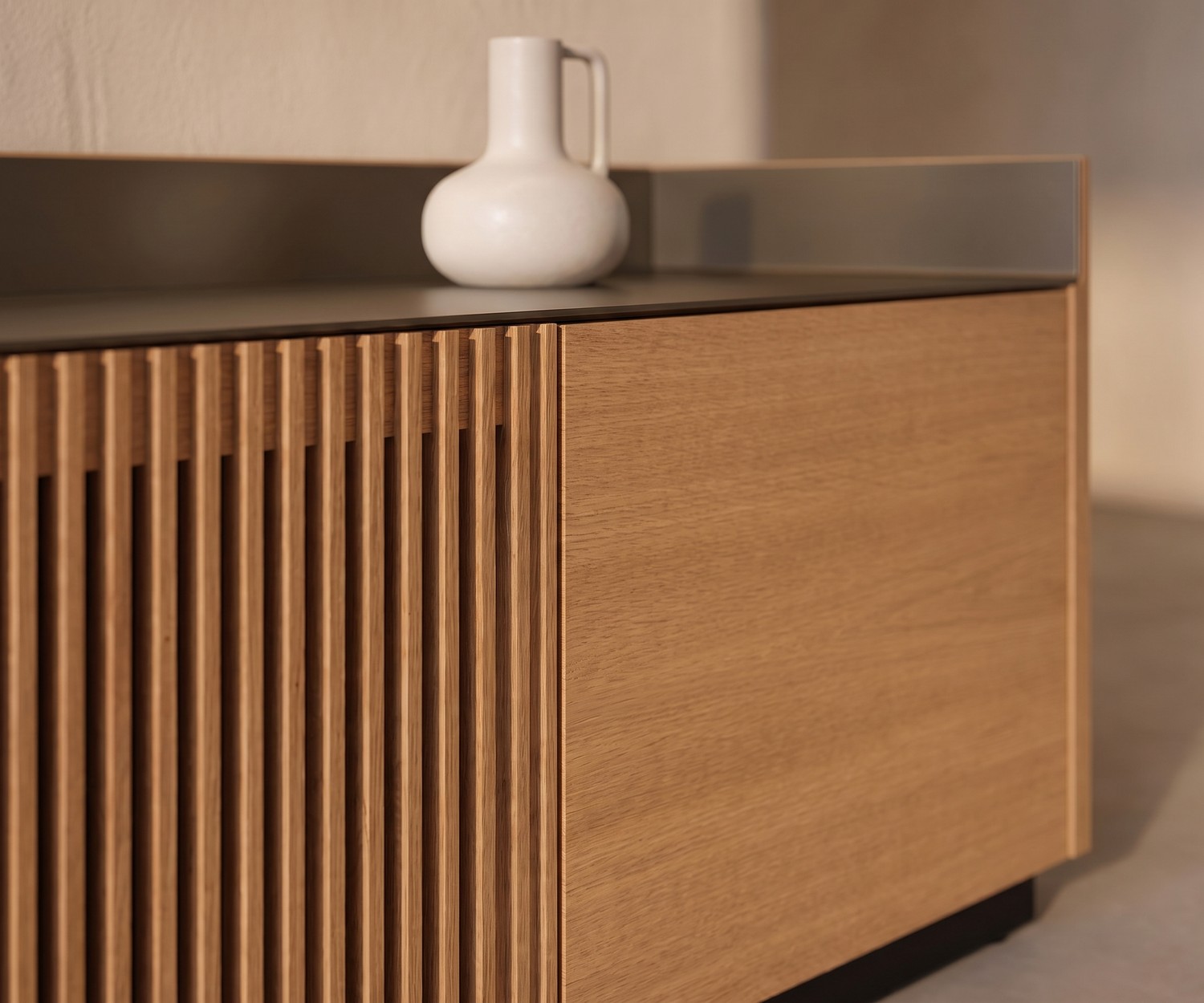 Punt Stockholm TV Lowboard mit Lamellenfront Punt Stockholm TV Lowboard aus Eiche mit Lamellenfront und Alu-Deckplatte im modernen Wohnzimmer mit Vase.