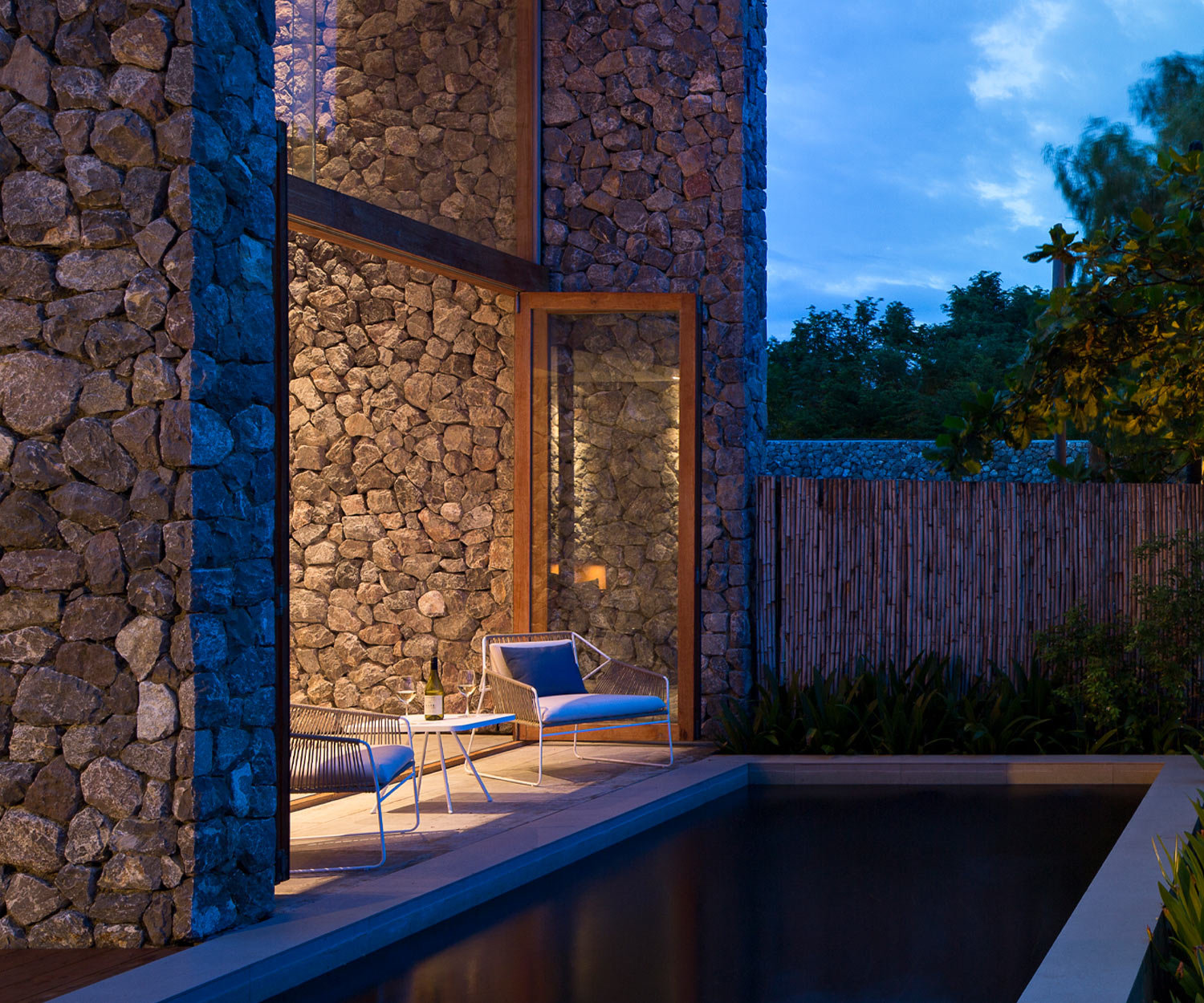 Weißer Sandur Outdoor Sessel von Oasiq am Pool abends Weißer Sandur Outdoor Sessel von Oasiq am Pool abends