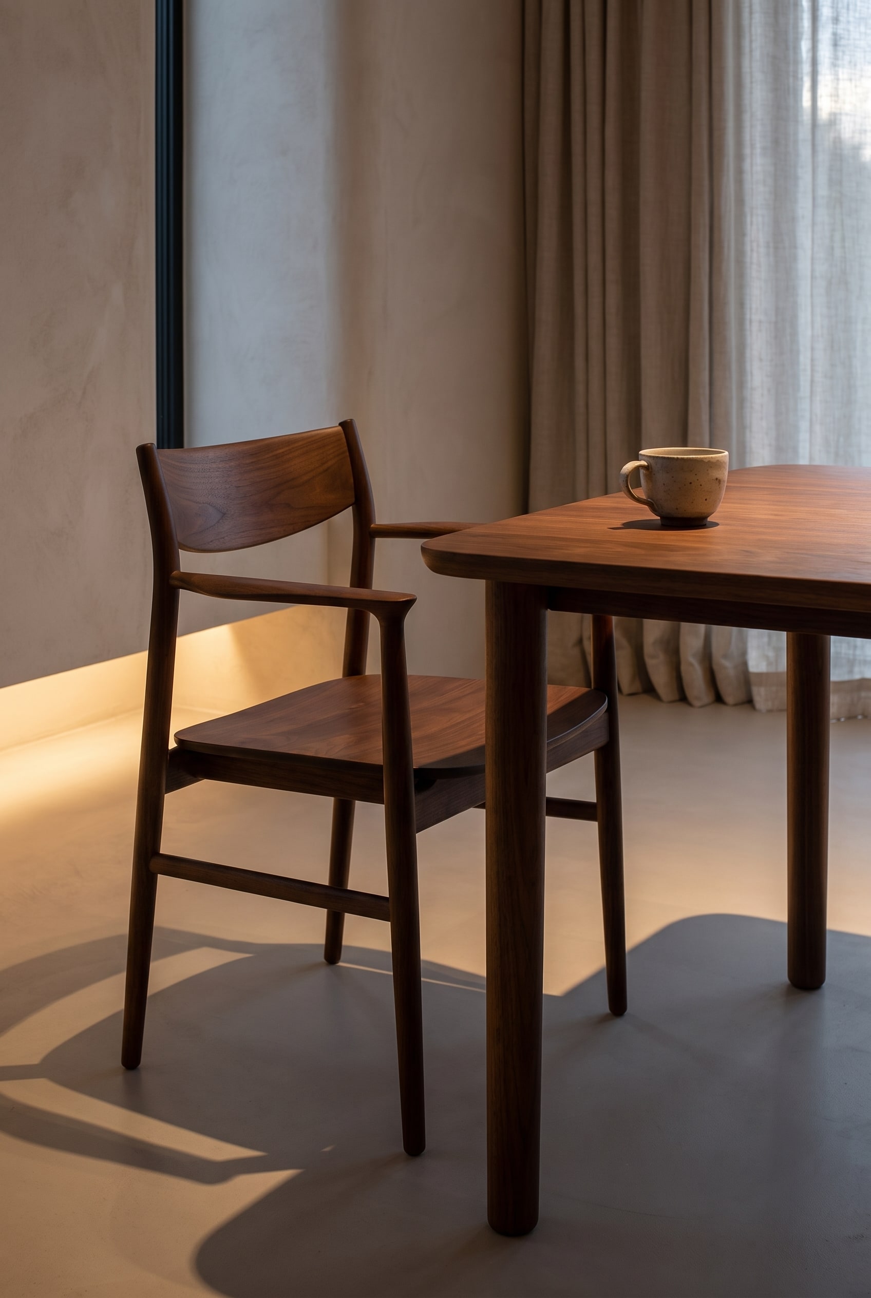 Detailaufnahme eines dunkelbraunen Holzstuhls mit flacher Silhouette und haptischer Sitzfl&auml;che am Esstisch