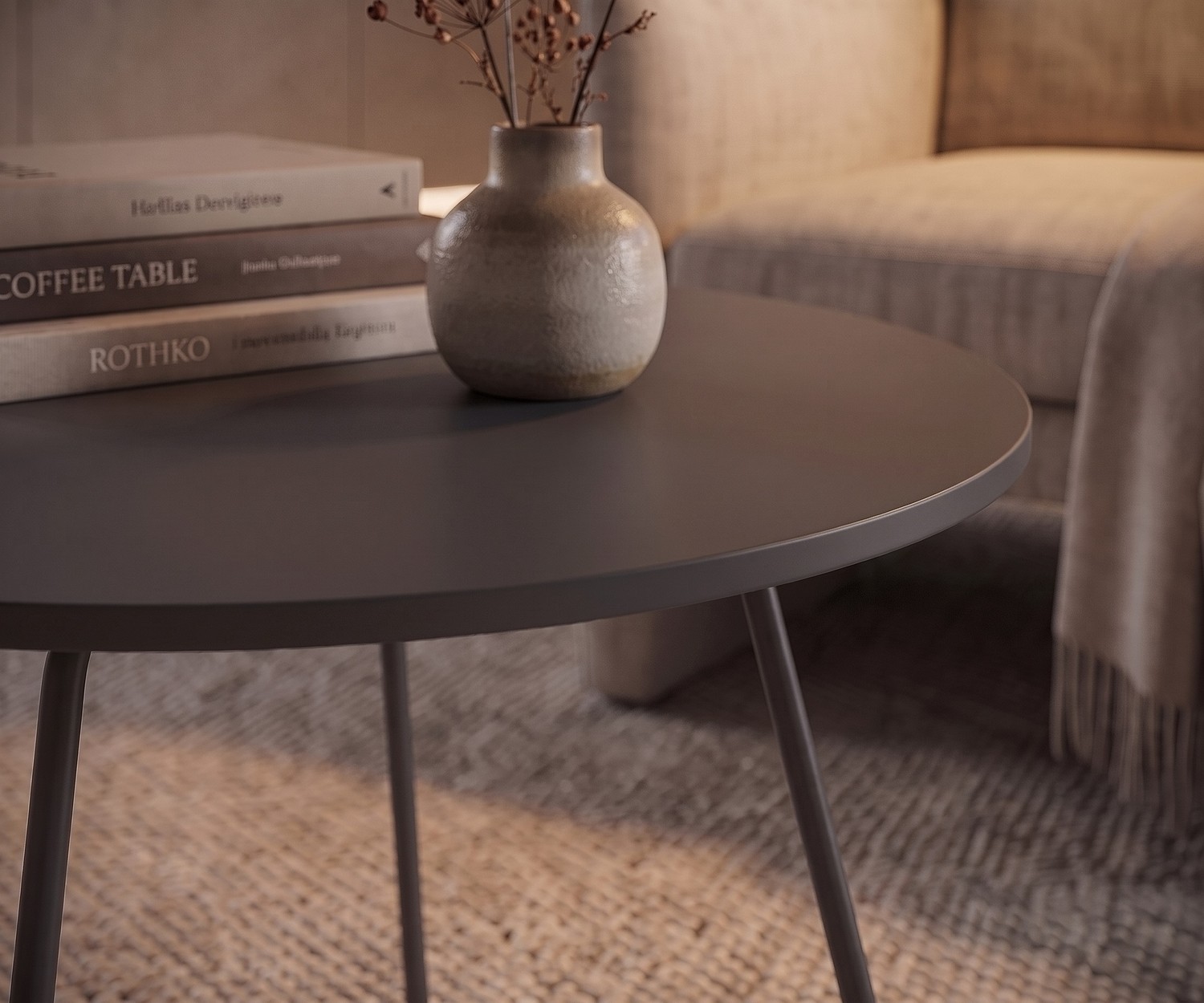 Novamobili Beistelltisch Orbis im Wohnzimmer. Runder, grauer Couchtisch neben Sessel mit Büchern und Vase.